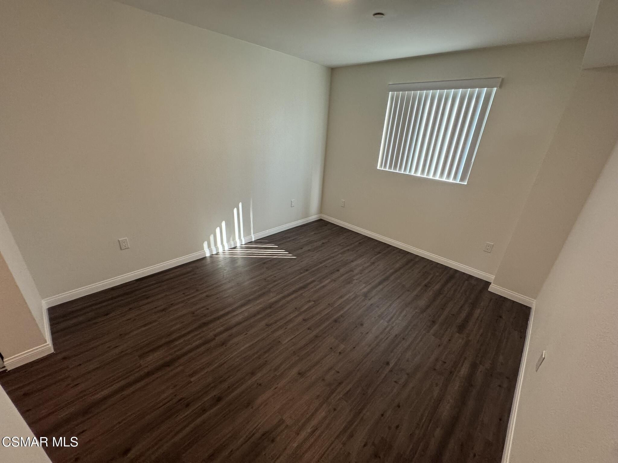 1850 Buyers Street, Unit 202 Simi Valley, CA 93063 - Photo 12 of 15 a view of an empty room with wooden floor and a window