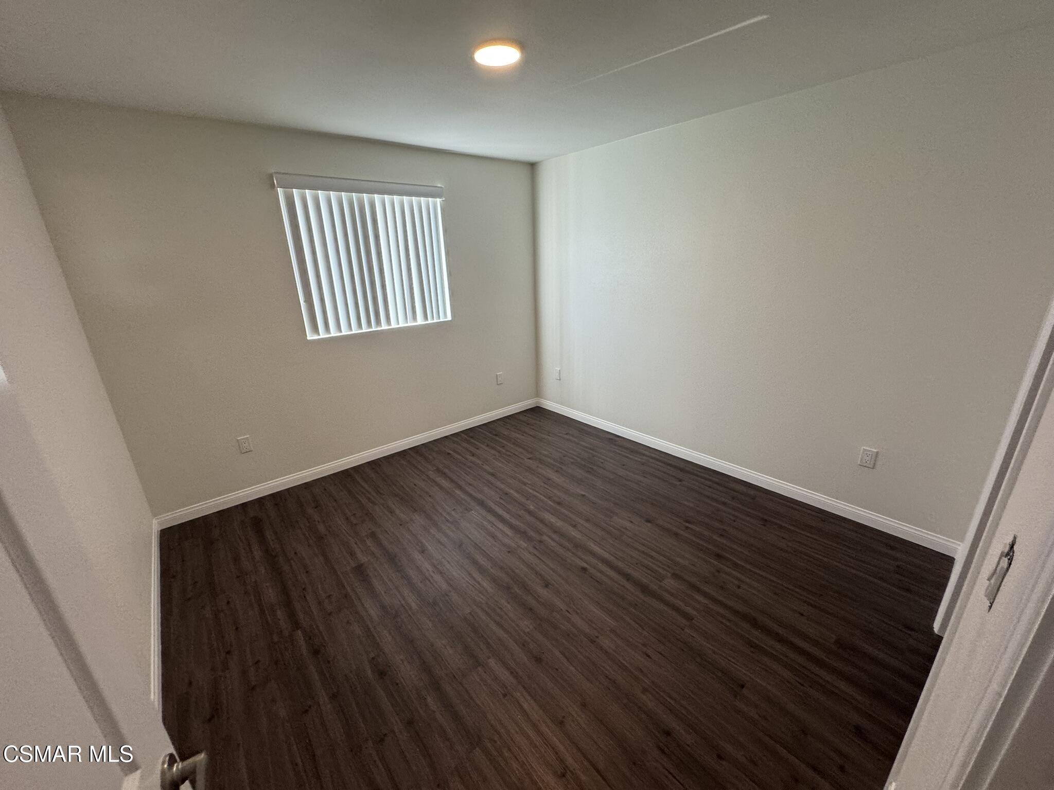 1850 Buyers Street, Unit 202 Simi Valley, CA 93063 - Photo 14 of 15 a view of an empty room with wooden floor and a window