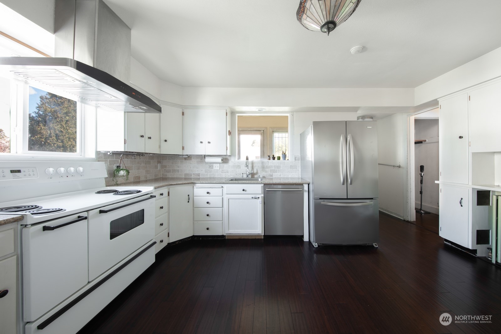 2202 Rucker Avenue Everett, WA 98201 - Photo 10 of 37 a kitchen with a white cabinets and wooden floor