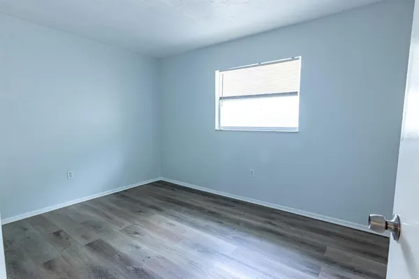 a view of an empty room with wooden floor