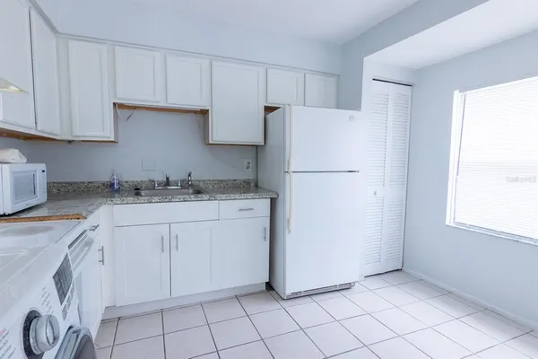 a kitchen with cabinets and a refrigerator