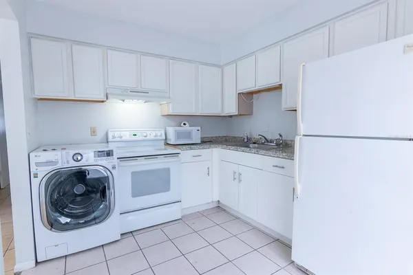 a kitchen with cabinets and refrigerator