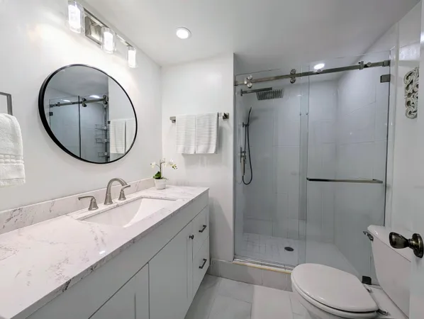 a bathroom with a granite countertop sink toilet and shower