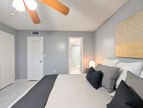 a bedroom with a large bed and a chandelier