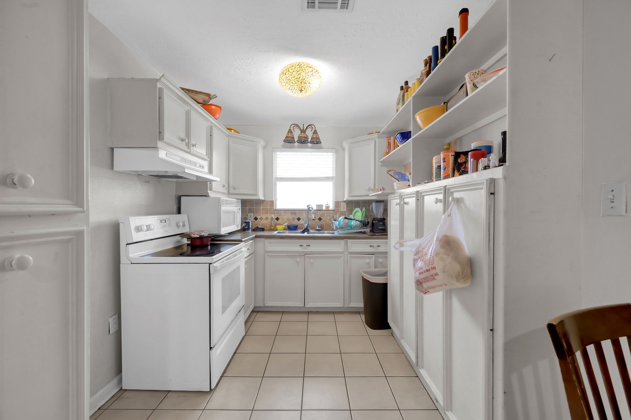 7644 Spring Cypress Road Spring, TX 77379 - Photo 25 of 28 a kitchen with a refrigerator and a stove