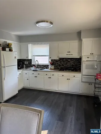 a kitchen with granite countertop a sink cabinets and stainless steel appliances