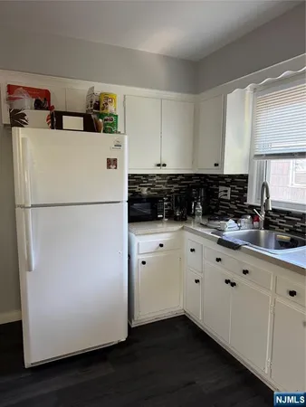a kitchen with refrigerator and cabinets