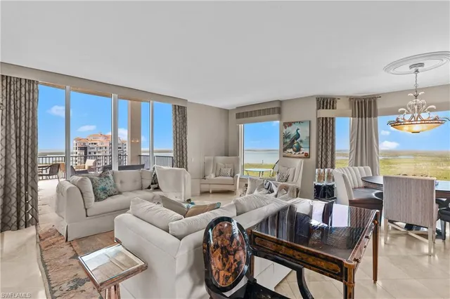 a living room with furniture fireplace and large windows