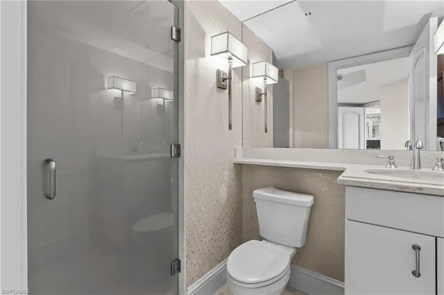 a bathroom with a toilet a sink a shower and mirror