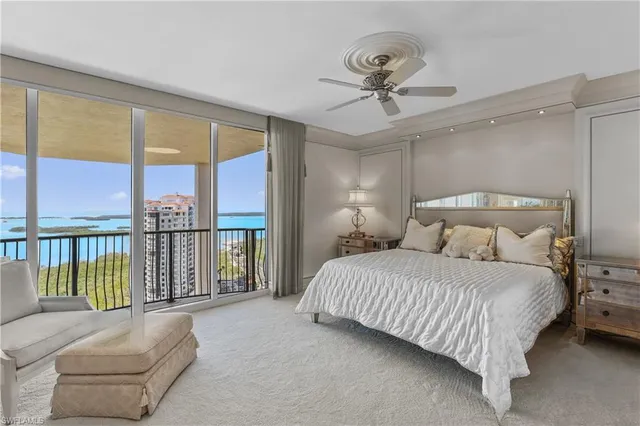 a bedroom with a large bed and a chandelier fan