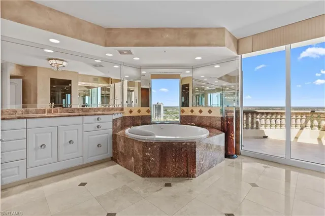 a spacious bathroom with a tub sink and mirror