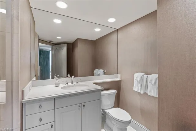 a bathroom with a toilet sink and mirror