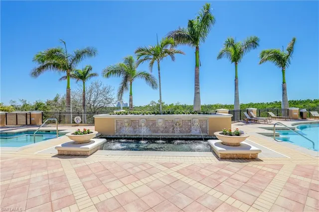 a view of swimming pool with outdoor seating and a palm tree