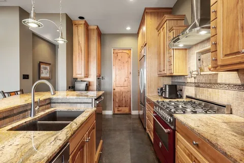 a kitchen with a sink stove top oven and refrigerator