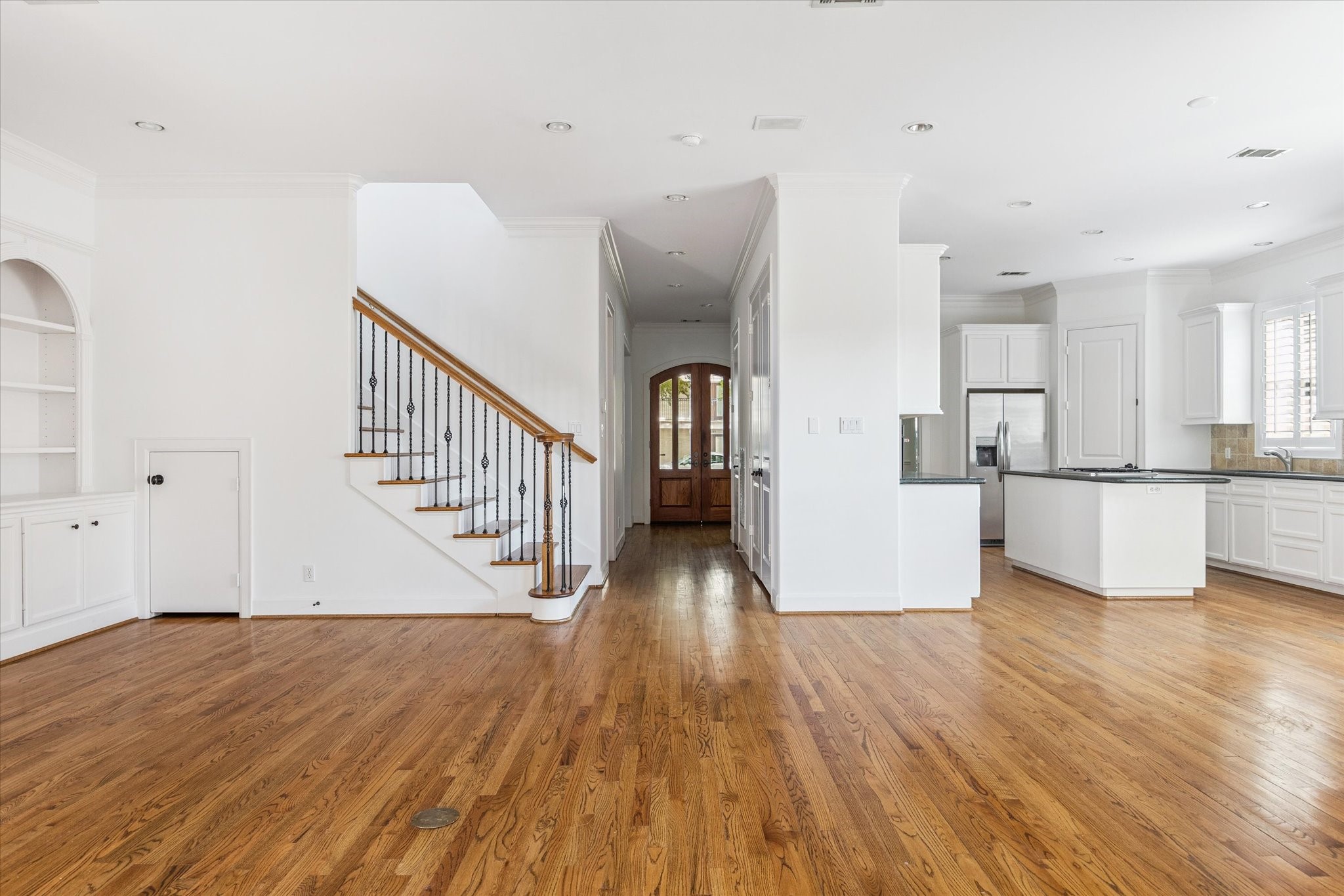 6106 Fordham Street Houston, TX 77005 - Photo 33 of 33 A warm and inviting entry welcomes you with rich hardwood floors, crisp white walls, and classic millwork. The sweeping staircase with wrought-iron balusters and wood rail adds a timeless focal point while offering a glimpse into the open-concept floor plan.
