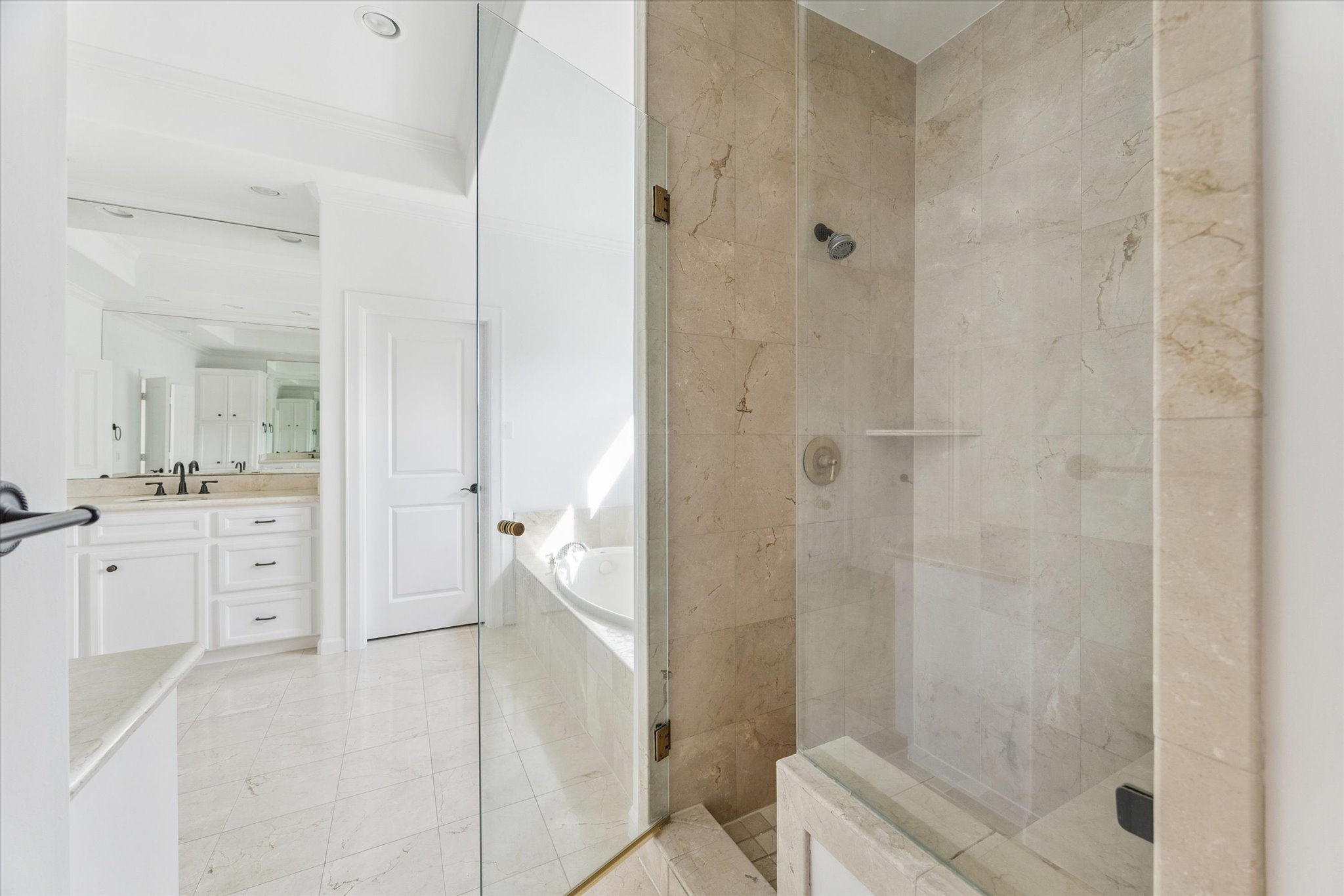6106 Fordham Street Houston, TX 77005 - Photo 18 of 33 A closer look at the spa-style walk-in shower with frameless glass enclosure and coordinating marble tile surround.