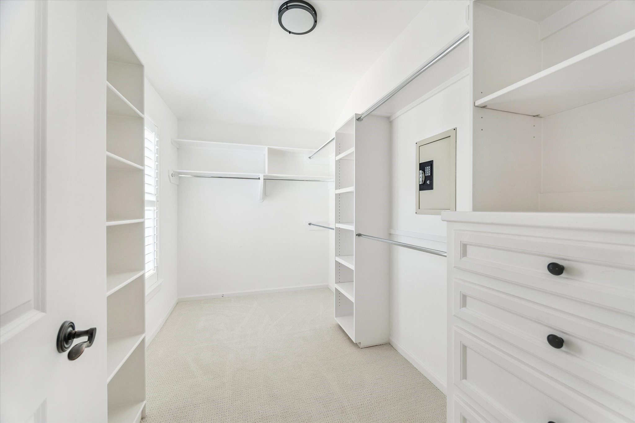 6106 Fordham Street Houston, TX 77005 - Photo 19 of 33 The expansive primary walk-in closet offers abundant hanging space, built-in drawers, shelving, and a secure wall safe—designed for both organization and convenience.