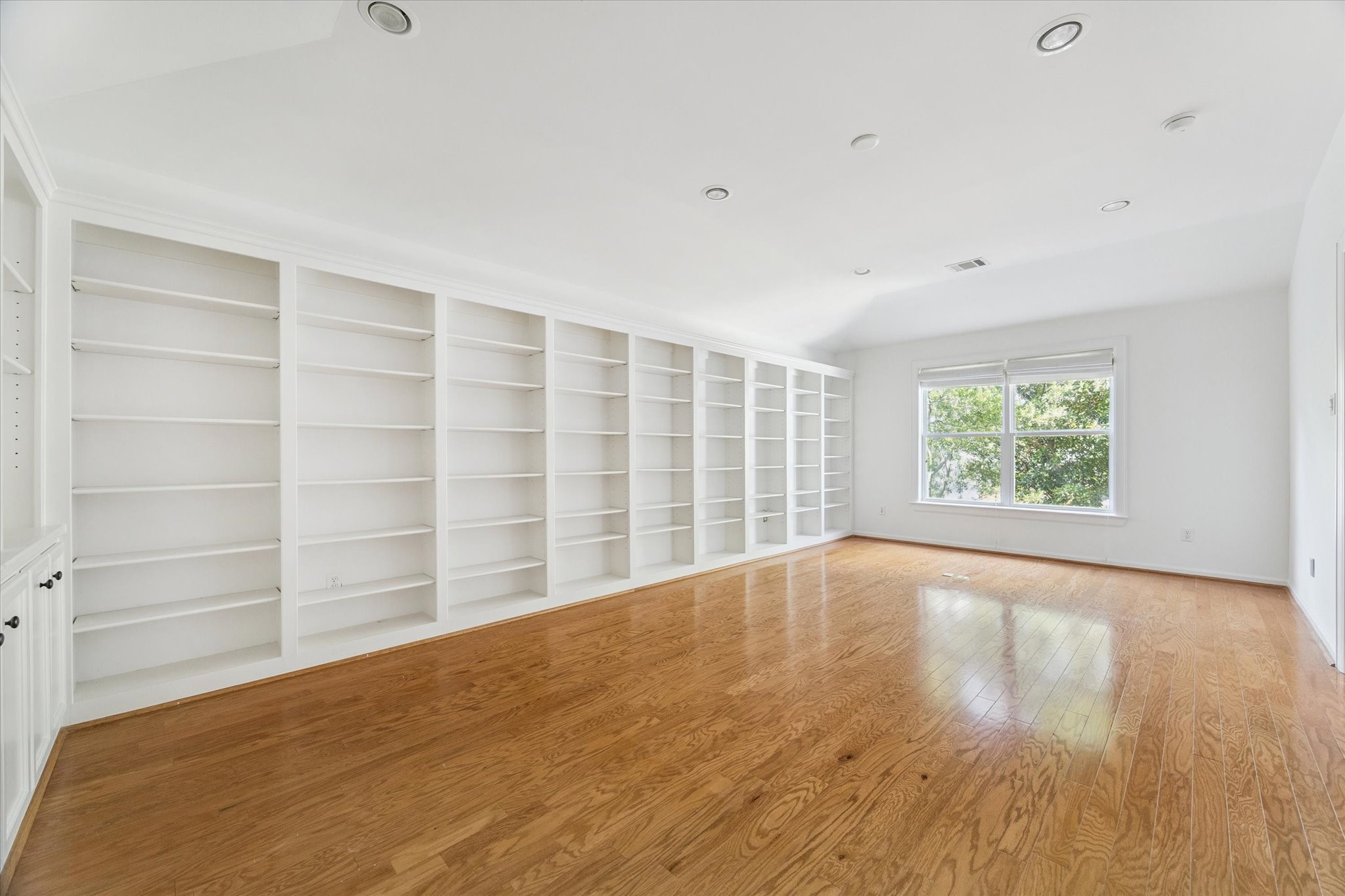 6106 Fordham Street Houston, TX 77005 - Photo 21 of 33 Expansive upstairs study lined with custom wall-to-wall bookshelves—ideal for a home library or media room.