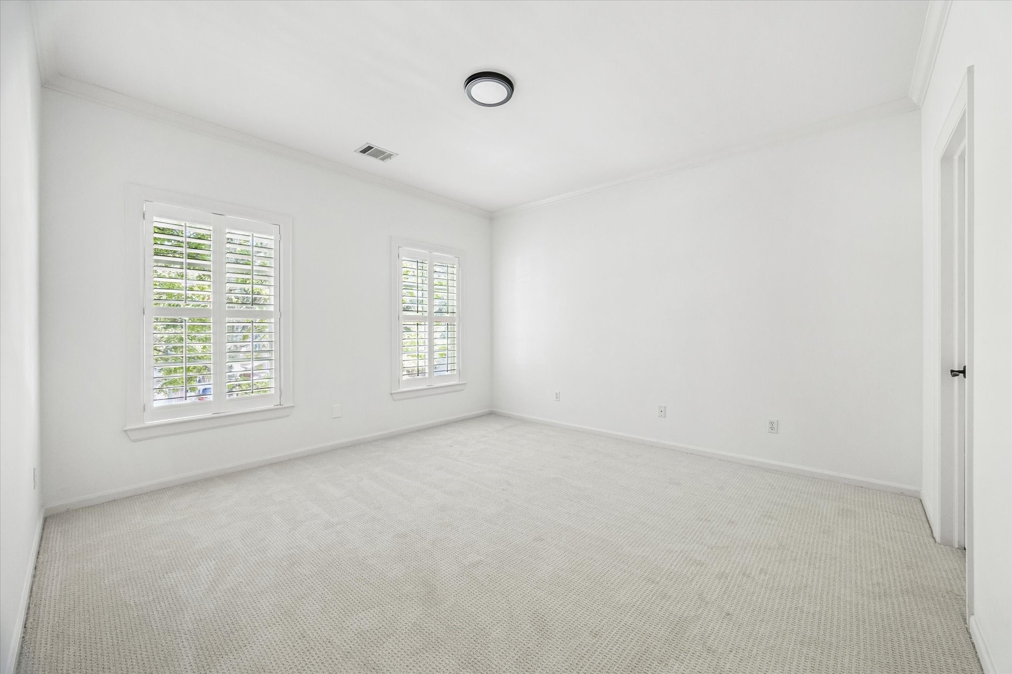 6106 Fordham Street Houston, TX 77005 - Photo 24 of 33 Another generously sized bedroom with abundant natural light and crisp white finishes, offering flexibility for a nursery, guest suite, or office.