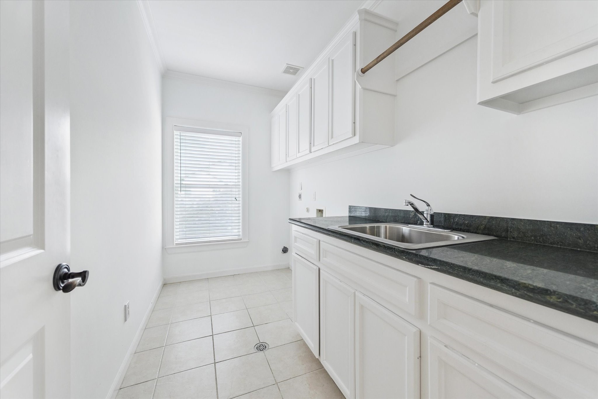 6106 Fordham Street Houston, TX 77005 - Photo 28 of 33 Bright and functional utility room with built-in cabinetry, utility sink, and countertop workspace—conveniently located upstairs.