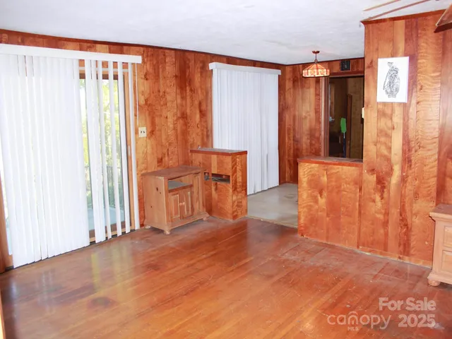 a view of a room with large windows and furniture