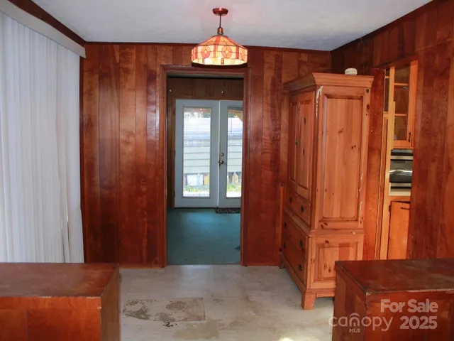 a view of a hallway with wooden cabinet and door