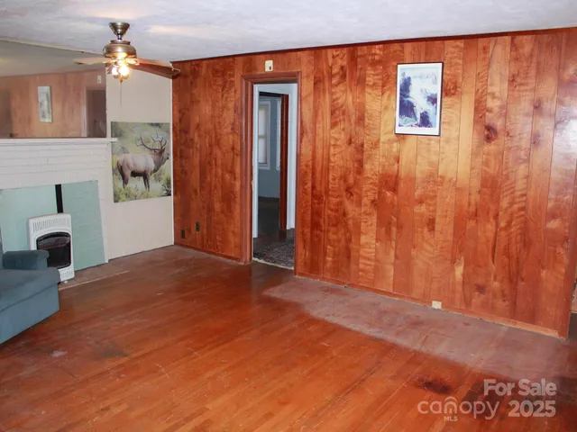 a view of empty room with a fireplace and wooden floor
