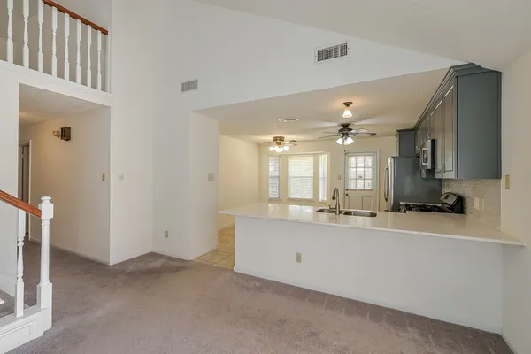 a large white kitchen with granite countertop a sink and dishwasher a stove with wooden floor