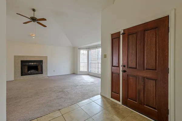 an empty room with windows cabinet and a fireplace