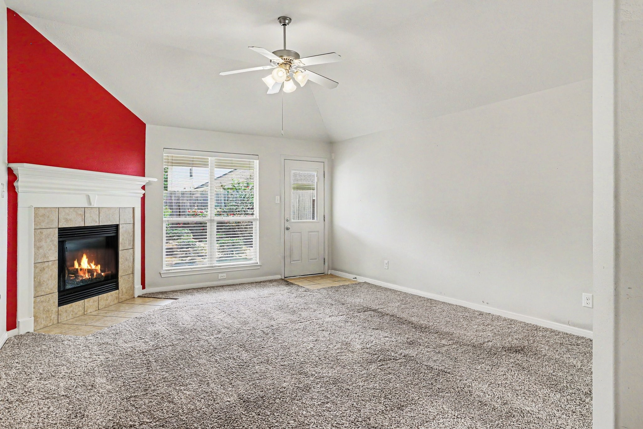 25222 Ginger Ranch Drive Katy, TX 77494 - Photo 14 of 33 Living room with gas fireplace surrounded by a red accent wall and ample natural light from a large window.