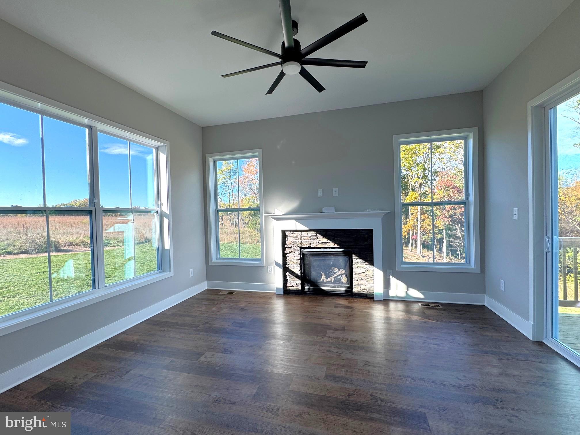 8 Glenaire Road Bunker Hill, WV 25413 - Photo 5 of 17 a view of an empty room with window a fireplace and wooden floor