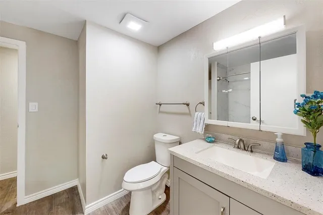 a bathroom with a sink a toilet and shower