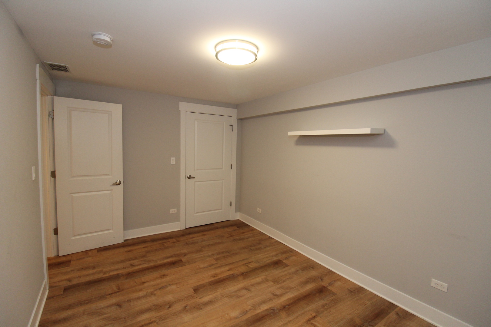 1411 West Taylor Street, Unit 1R Chicago, IL 60607 - Photo 16 of 17 an empty room with wooden floor and windows