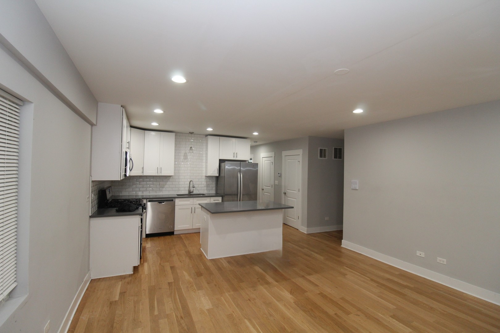 1411 West Taylor Street, Unit 1R Chicago, IL 60607 - Photo 3 of 17 a large kitchen with stainless steel appliances a large counter top a stove a microwave and a refrigerator