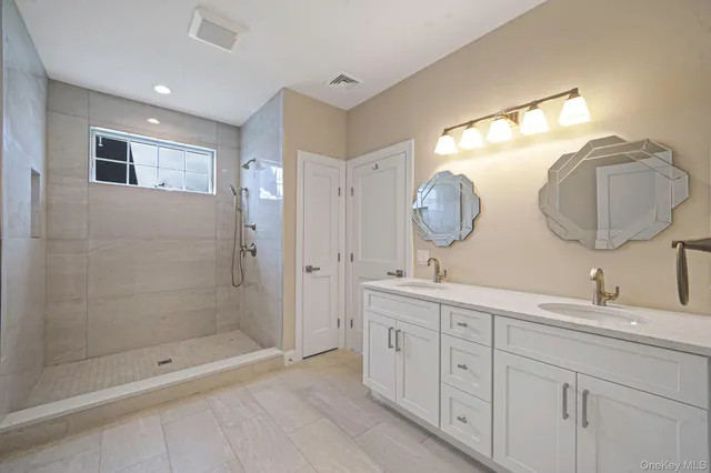 a bathroom with a double vanity sink and a mirror