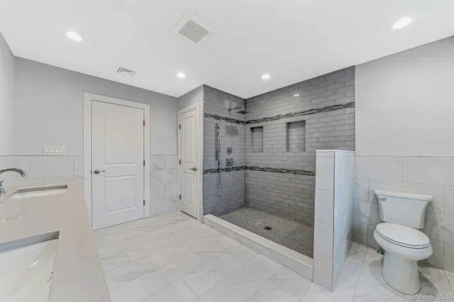 a bathroom with a shower a toilet and a sink