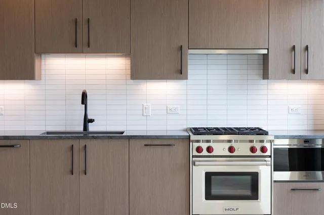 a kitchen with stainless steel appliances granite countertop a stove a sink and a refrigerator