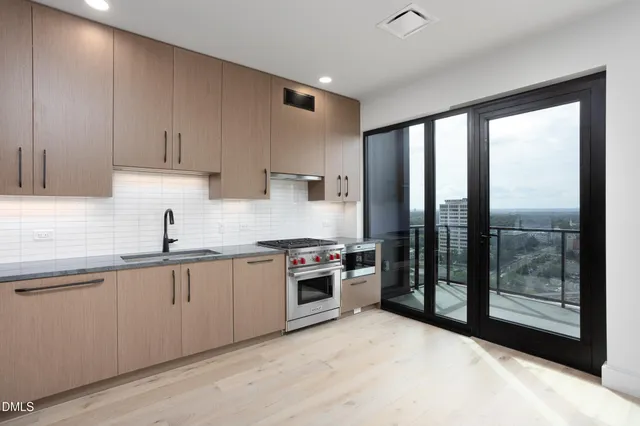 a kitchen with white cabinets and sink