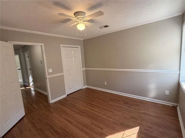 an empty room with wooden floor and window