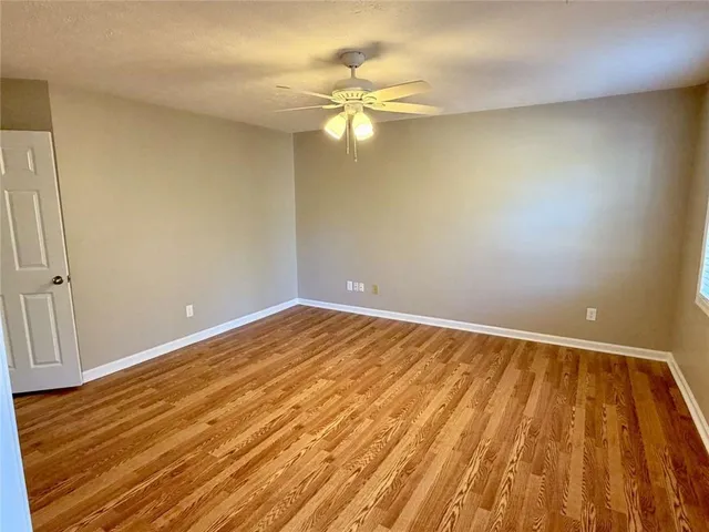 a view of a room with wooden floor and a ceiling fan