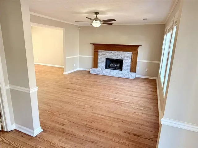 a view of an empty room with a window and a fireplace