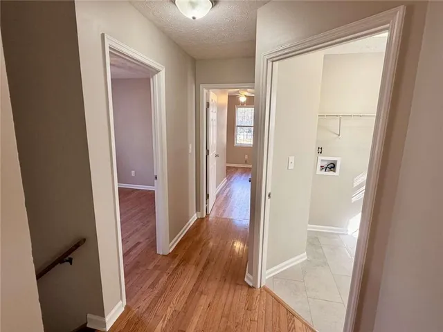 a view of a hallway with wooden floor and closet