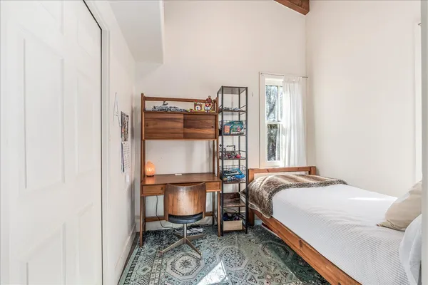 a bedroom with a bed chair and a window