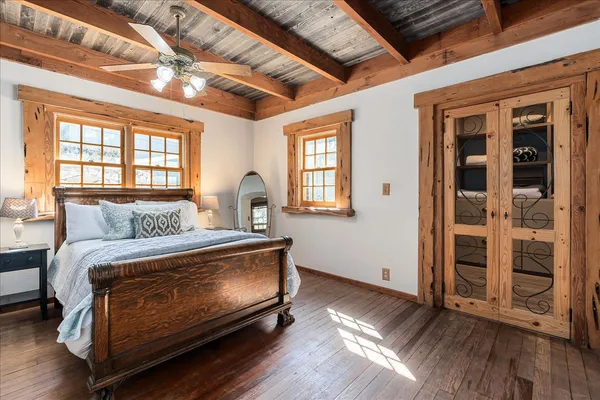 a bedroom with bed and wooden floor