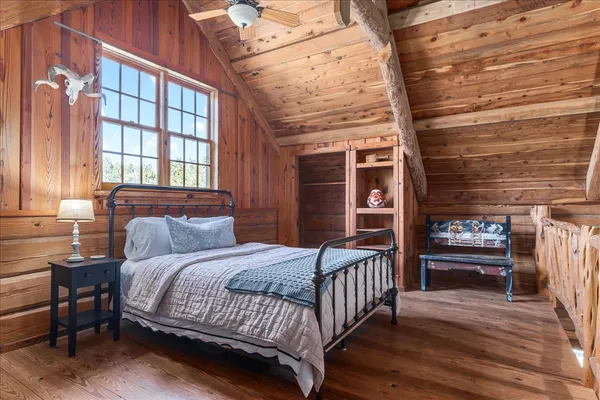 a bedroom with a bed wooden floor and a window