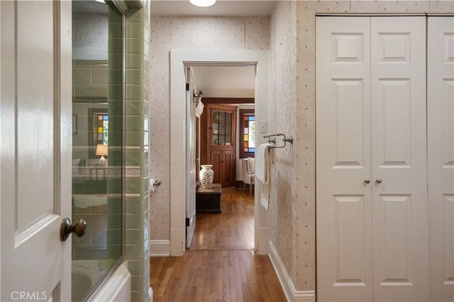 a view of a hallway with wooden floor and closet area