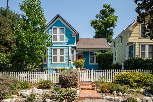 a large kitchen with granite countertop a large stove a sink dishwasher and white cabinets with wooden floor