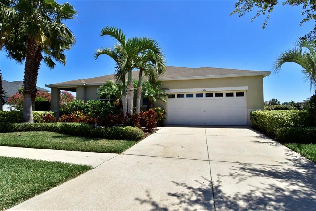5424 Sandy Shell Drive Apollo Beach, FL 33572 - Photo 1 of 1 a front view of a house with a yard and garage