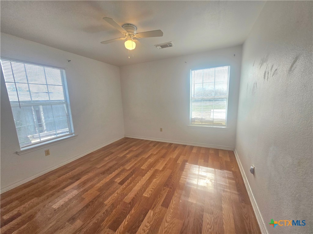 819 South 16th Street Temple, TX 76501 - Photo 4 of 7 wooden floor in an empty room with a window