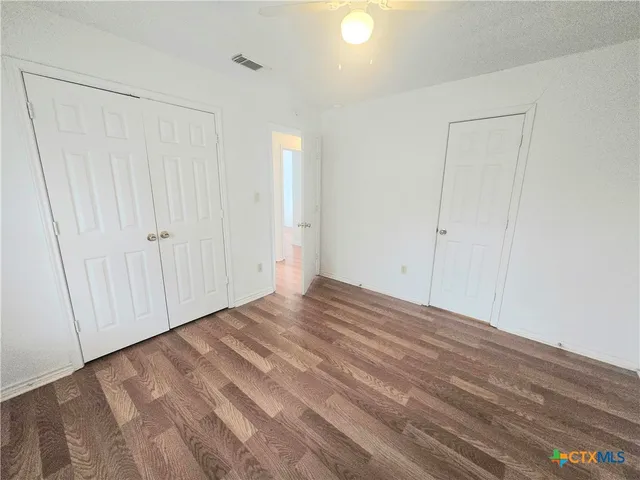 a view of empty room with wooden floor